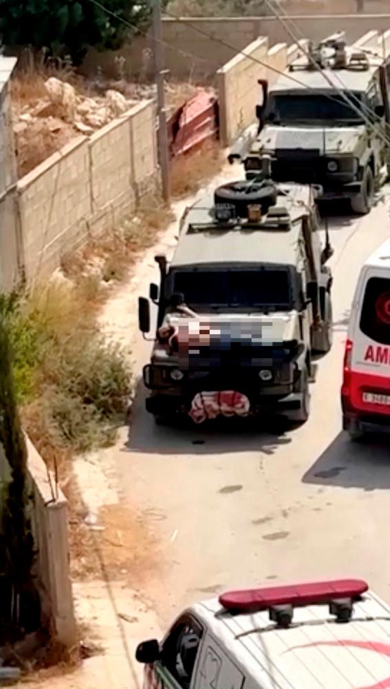 Israeli army straps Palestinian on military jeep during raid in Jenin, in this screengrab from a video, in the Israeli-occupied West Bank. - REUTERS/Reuters TV