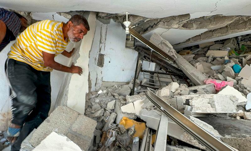 A Palestinian man walks through the rubble of a house where Hamas leader Ismail Haniyeh's sister and other relatives were killed in an Israeli strike, amid Israel-Hamas conflict, at the Shati (Beach) refugee camp, in Gaza City - REUTERSpix