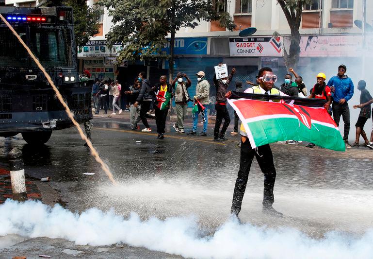 A demonstrator holds a Kenyan flag as police use water cannons and tear gas to disperse protesters during a demonstration against Kenya's proposed finance bill 2024/2025 in Nairobi - REUTERSpix
