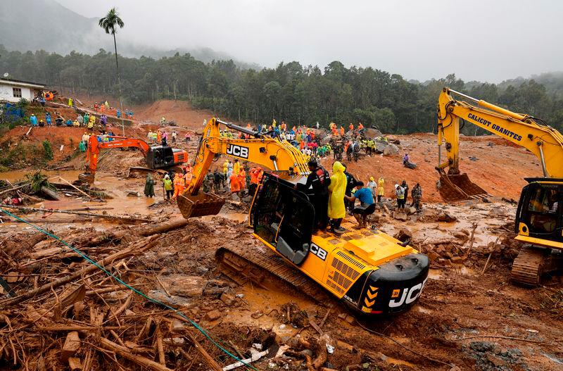 People stand as search operations are carried out after landslides hit Mundakkai village in Wayanad district in the southern state of Kerala - REUTERSpix