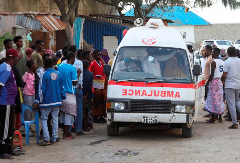 People gather as an ambulance carries the dead body of an unidentified woman killed in an explosion that occurred while revellers were swimming at the Lido beach in Mogadishu, Somalia August 3, 2024. - REUTERS/Feisal Omar