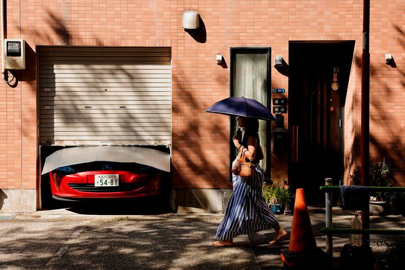 A woman with an umbrella covering her face from the sun walks along a neighbourhood during a hot summer day in Tokyo, Japan, August 2, 2024. - REUTERS/Willy Kurniawan