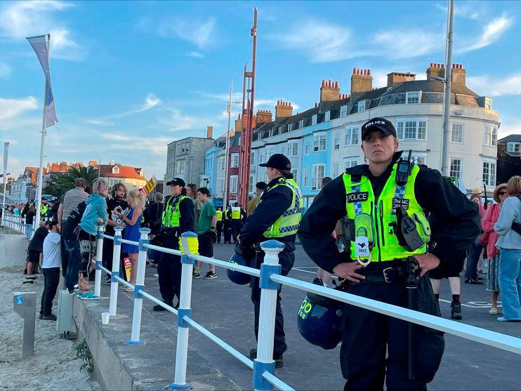 Police wearing riot protection equipment patrol the seafront esplanade following an anti-immigration protest in Weymouth, Britain/REUTERSPIX