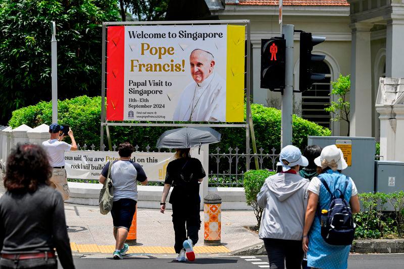 People walk past a poster of Pope Francis, ahead of his visit to Singapore, at the Cathedral of the Good Shepherd, Singapore, September 11, 2024.REUTERSPIX