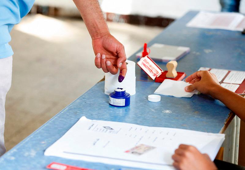 A person has indelible ink applied to his finger as he votes at a polling station during the presidential election in Tunis, Tunisia October 6, 2024. - REUTERS/Zoubeir Souissi