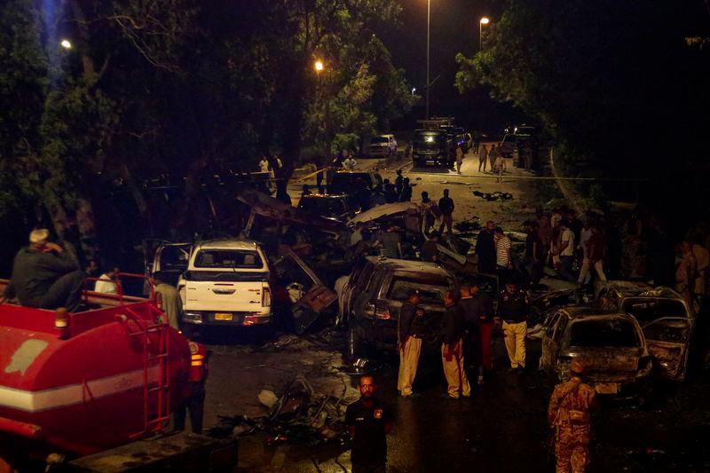 Police officers and paramilitary soldiers gather near the wreckage of vehicles after an explosion near Jinnah International Airport in Karachi, Pakistan October 6, 2024. - REUTERSPIX