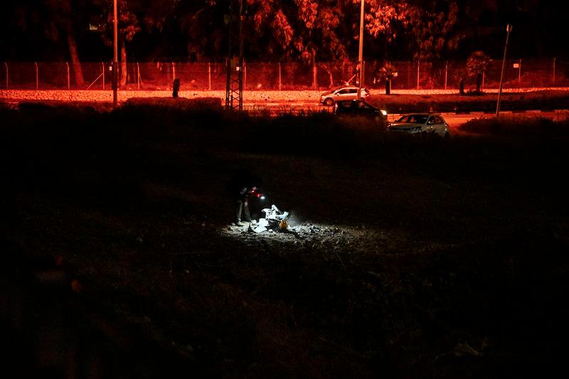 An Israeli police officer inspects the remains of a projectile after a rocket was fired from Lebanon and landed in Israel, amid cross-border hostilities between Hezbollah and Israel, in Haifa, Israel, October 7, 2024. - REUTERSPIX