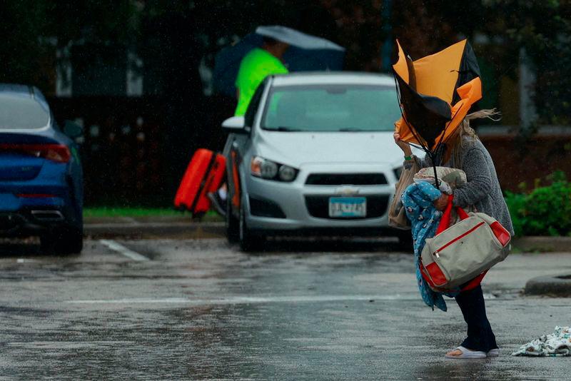 A woman holds an umbrella while arriving at a shelter as Hurricane Milton approaches, in Lakeland, Florida, U.S., October 9, 2024. - REUTERSPIX