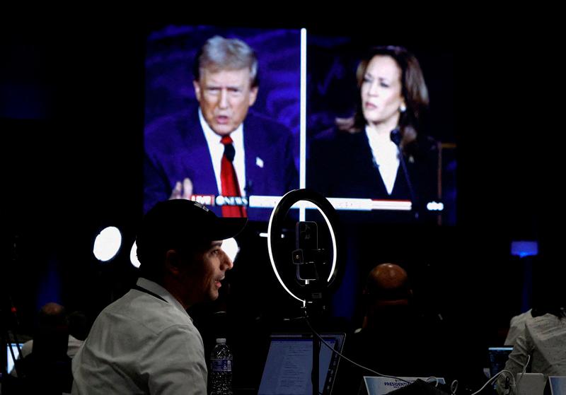 FILE PHOTO: Members of the media use a screen to watch the presidential debate, as Republican presidential nominee, former U.S. President Donald Trump and Democratic presidential nominee, U.S. Vice President Kamala Harris attend a presidential debate hosted by ABC in Philadelphia, Pennsylvania, U.S., September 10, 2024. - REUTERS/Evelyn Hockstein/File Photo