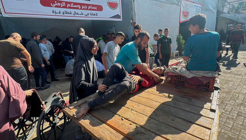 Palestinian assist casualties following an Israeli strike, amid the Israel-Hamas conflict, in Beit Lahiya in the northern Gaza Strip - REUTERSpix