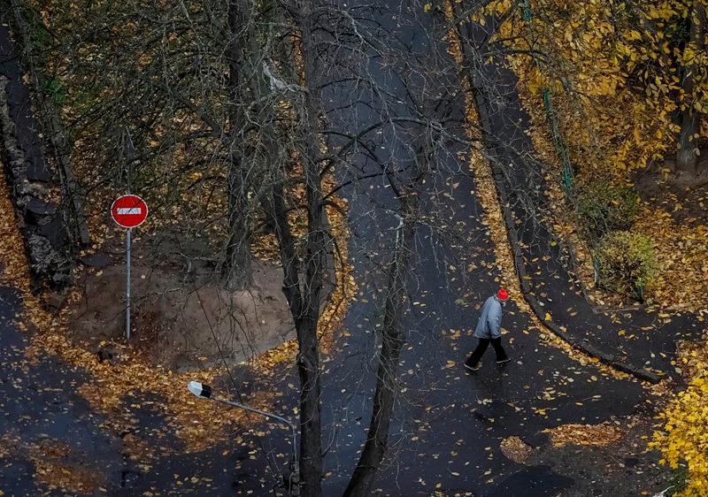 A man walks down the street on a rainy morning during an air raid alarm, amid Russia's attack on Ukraine, in Kyiv, Ukraine November 2, 2024. - REUTERS/Gleb Garanich