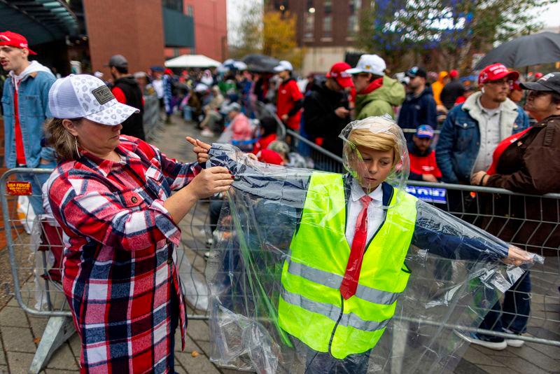 Kruz Chamberlain’s mom helps him put on a rain cover as people wait in line outside the venue where Republican presidential nominee and former U.S. President Donald Trump is expected to hold a campaign rally in Grand Rapids, Michigan, U.S. Reuterspix