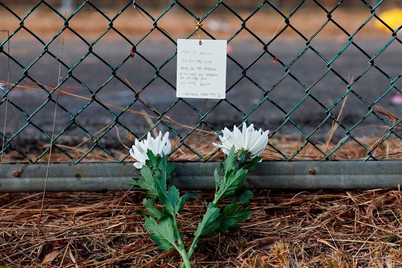 Flowers and a message of condolence laid by people working at the site where an aircraft went off the runway and crashed, are pictured at Muan International Airport in Muan - REUTERSpix