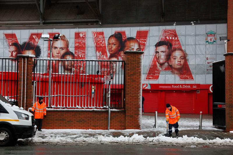 Workers clear snow outside the stadium before the match. Photo: Reuters