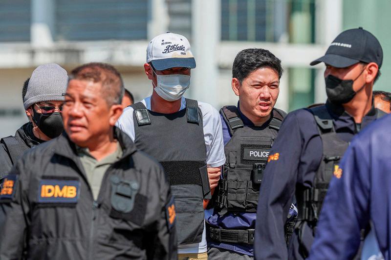 Ekkalak Paenoi, a suspect in the assassination of a former politician with now-dissolved Cambodia National Rescue Party (CNRP) Lim Kimya, 74, is escorted by police officers as he arrives in Thailand following handing over from Cambodia to Thai authorities, in Bangkok, Thailand, January 11, 2025. - REUTERS/Chalinee Thirasupa