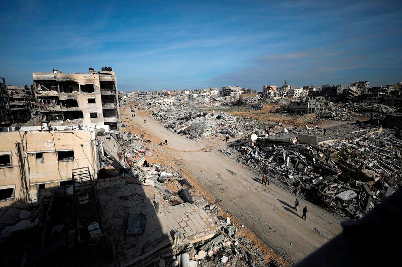 Palestinians walk past the rubble following a delay in the ceasefire between Israel and Hamas over the hostage list, in Gaza City, January 19, 2025. - REUTERS/Dawoud Abu Alkas