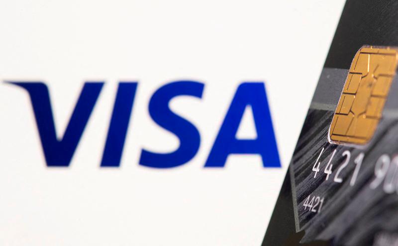 FILE PHOTO: A credit card is seen in front of a displayed Visa logo in this illustration taken July 15, 2021.- REUTERS/Dado Ruvic/Illustration/File Photo