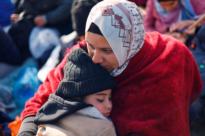 A woman embraces a child as Palestinians wait to be allowed to return to their homes in northern Gaza - REUTERSpix