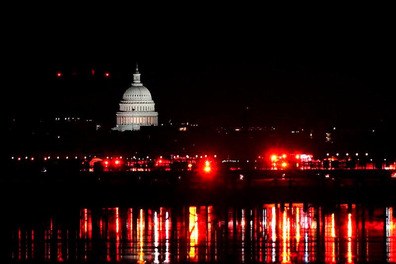 Emergency personnel work near the site of the crash, with the U.S. Capitol in the background, after American Eagle flight 5342 collided with a Black Hawk helicopter while approaching Ronald Reagan Washington National Airport and crashed in the Potomac River - REUTERSpix