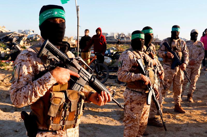 Palestinian Hamas militants stand guard before the release of hostages held in Gaza since the deadly October 7, 2023 attack, as part of a ceasefire and a hostages-prisoners swap deal between Hamas and Israel in Khan Younis, in the southern Gaza Strip, February 15, 2025. - REUTERSPIX