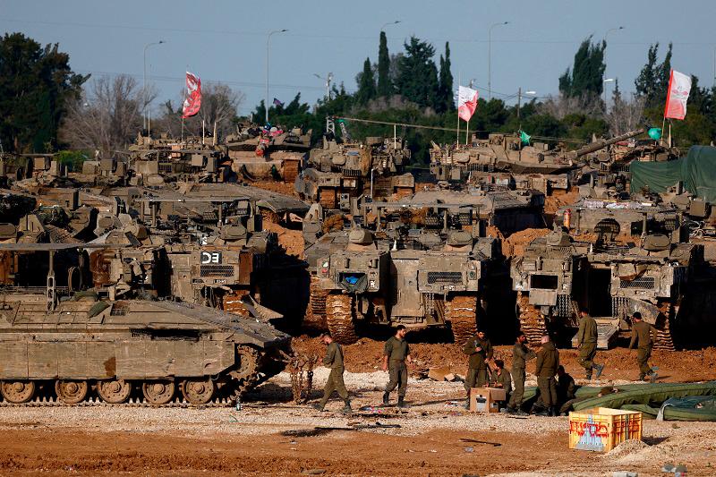 Israeli soldiers work by military vehicles, amid a ceasefire between Israel and Hamas, near the border with Gaza, in Israel, February 15, 2025. - REUTERS/Amir Cohen