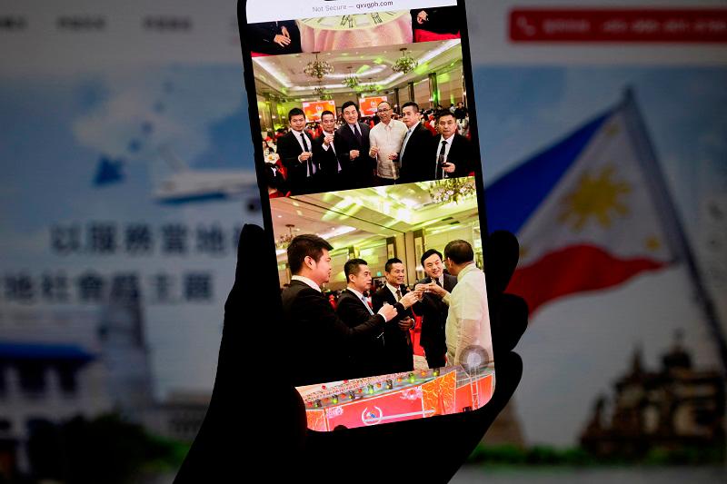 The website of the Qiaoxing Volunteer Group, a Chinese community organization in the Philippines, shows four men detained in late January in the Philippines on charges of espionage seen with Chinese defense attache Li Jianzhong and the governor of Cagayan province, Manuel Mamba, in this illustration picture taken February 27, 2025. - REUTERS/Eloisa Lopez To