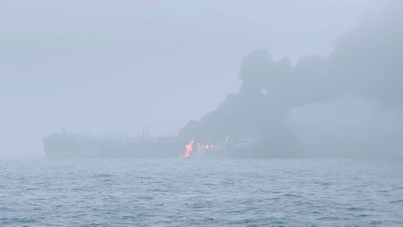 Flames and smoke rise from a collision between oil tanker and a cargo ship off the northeastern coast of England in this still picture obtained by Reuters.