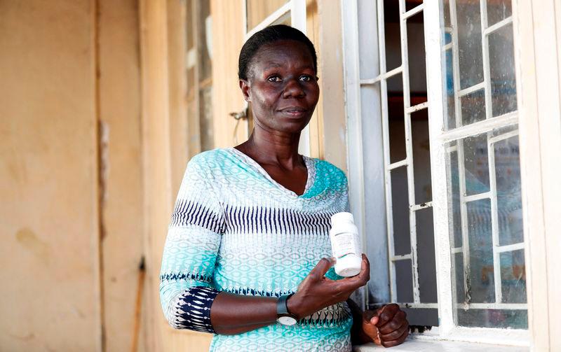 Alice Okwirry, 50, a widow living with HIV/AIDS, holds a bottle of anti-retroviral (ARV) drugs outside the pharmacy at the Ushirika Medical Clinic and Maternity Services, in Kibera district of Nairobi, Kenya. REUTERSpix