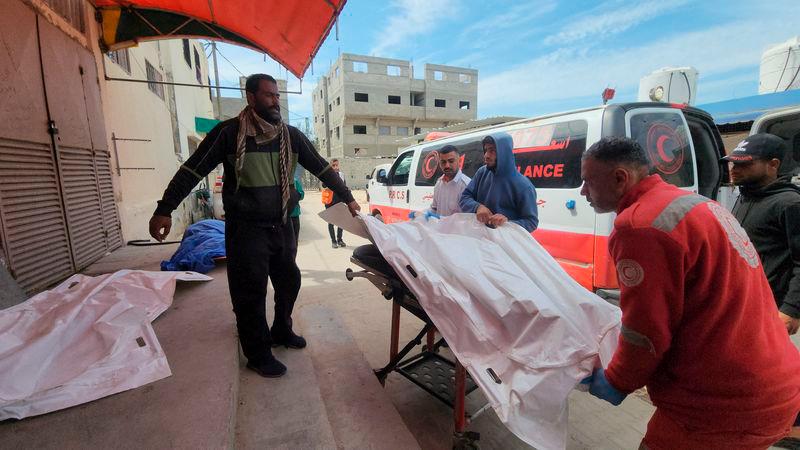 Mourners and a paramedic move the body of a Palestinian, killed in an Israeli strike - REUTERSpix