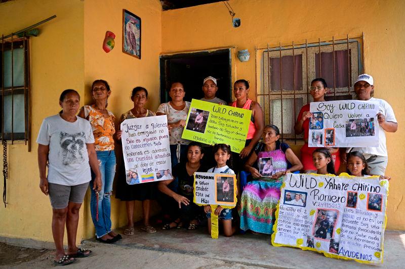 Family members of Venezuelan Wild Chirinos, 28, who is held in a high-security prison in El Salvador after being deported from the U.S., hold signs and pictures of him, in Valencia, Venezuela. REUTERSpix