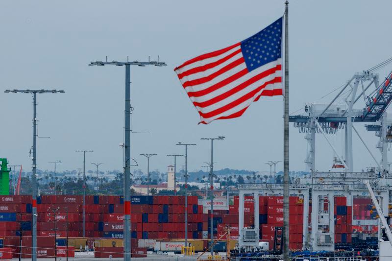 An American flag flutters near Chinese shipping containers at the Port of Los Angeles, in San Pedro, California, U.S., May 1, 2025. REUTERSpix