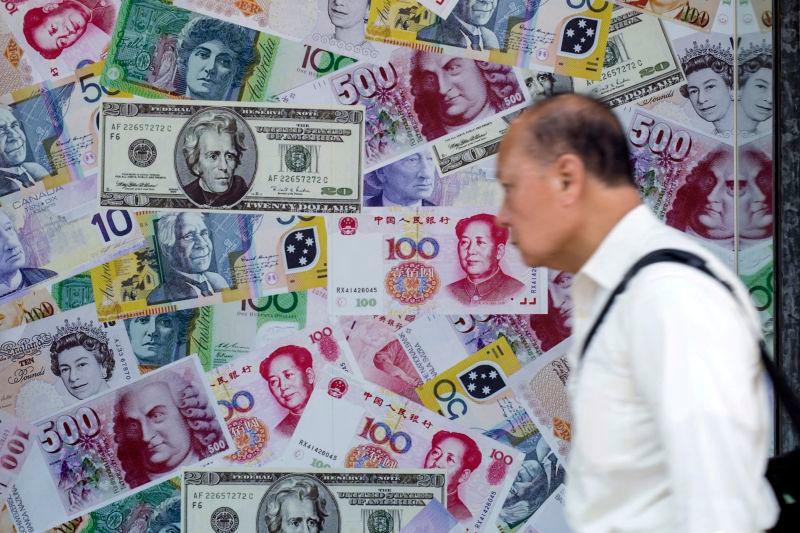 A man walks past an advertisement promoting China’s renminbi (RMB) or yuan, U.S. dollar and Euro exchange services at foreign exchange store in Hong Kong, China, August 13, 2015. REUTERSpix