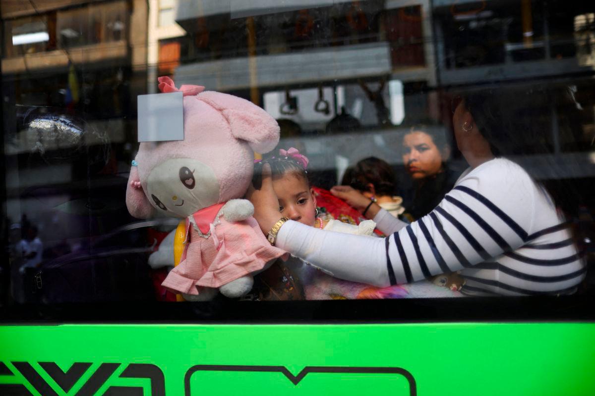 A migrant girl from Venezuela looks on through the window of the bus taking her and her family to their embassy, while on their way to take a flight back to Venezuela, in Mexico City, Mexico May 7, 2025. REUTERSpix