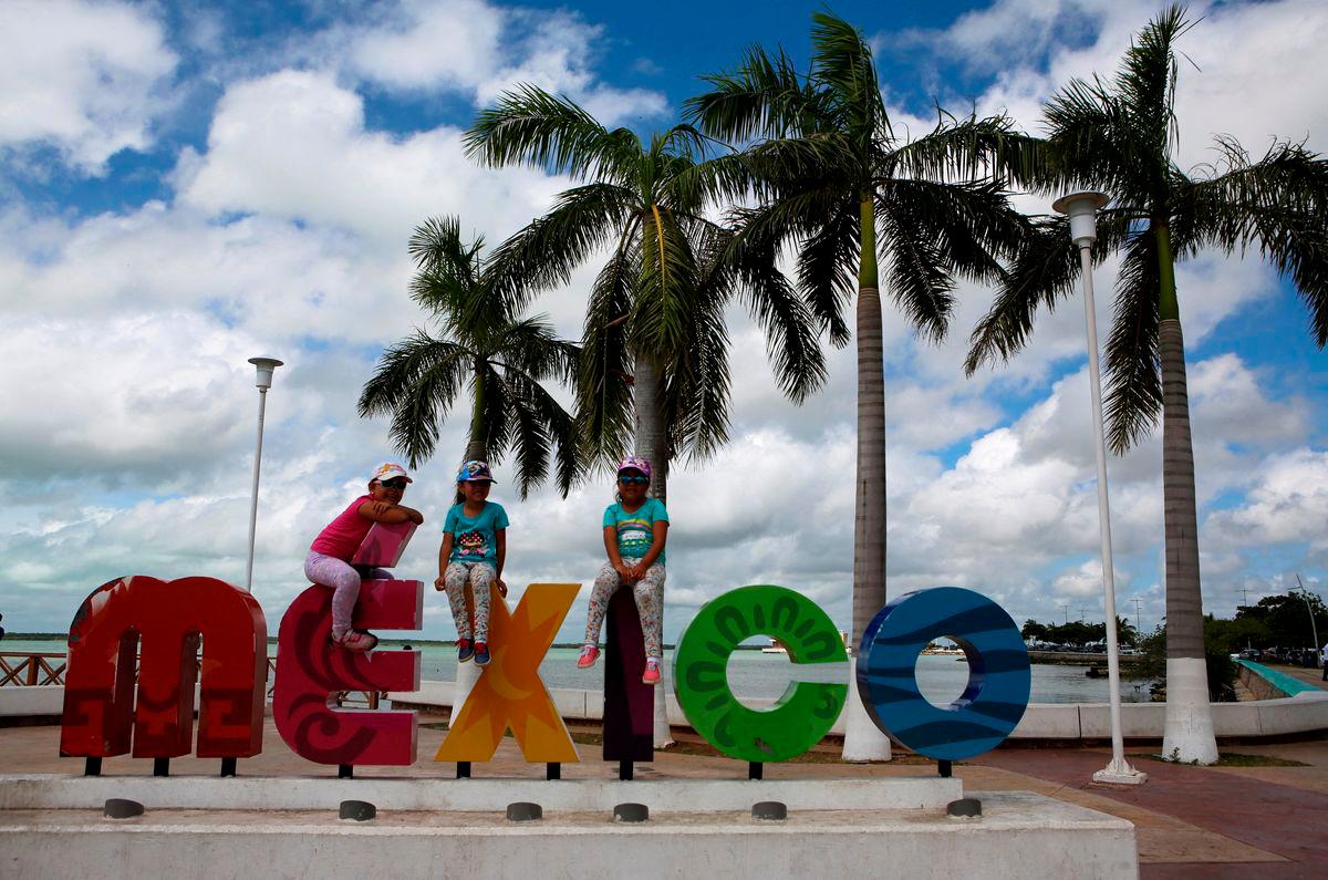 Children sit on top a sign in Chetumal in the state of Quintana Roo, Mexico August 3, 2016. REUTERSpix