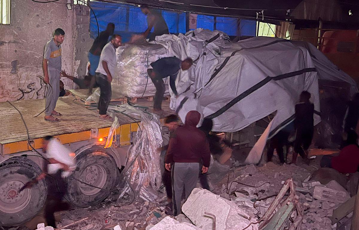 Palestinian workers unload sacks of flour from an aid truck at a bakery, in Khan Younis, southern Gaza Strip, May 21, 2025. - REUTERSPIX
