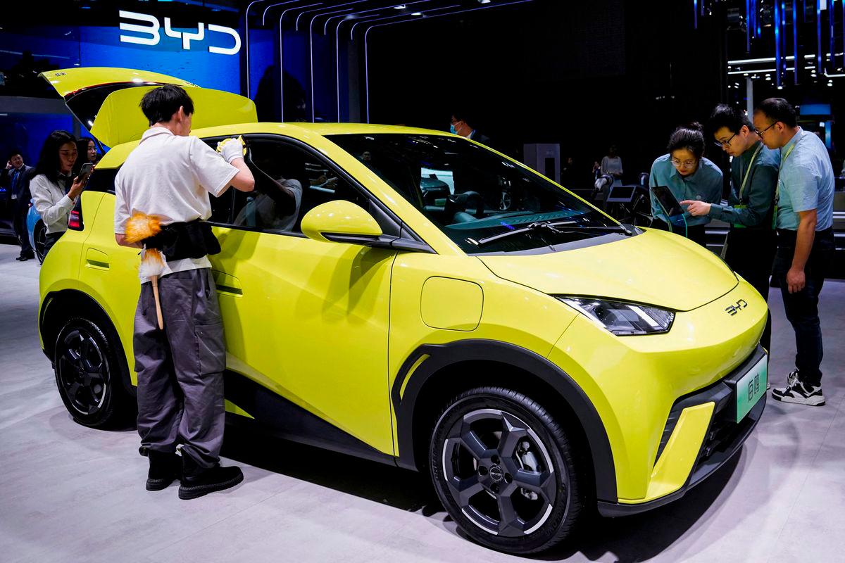 People use their phones in front of the BYD Seagull that is displayed at the Auto Shanghai show, in Shanghai, China April 19, 2023. REUTERSpix