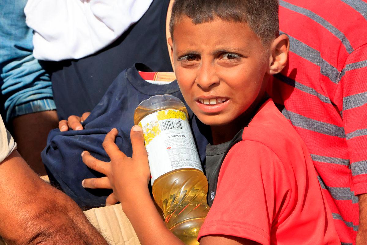 A youngster carries food aid as Palestinians seeking aid gather near an aid distribution site run by the U.S.-backed Gaza Humanitarian Foundation, in Rafah, in the southern Gaza Strip, May 27, 2025. REUTERSpix