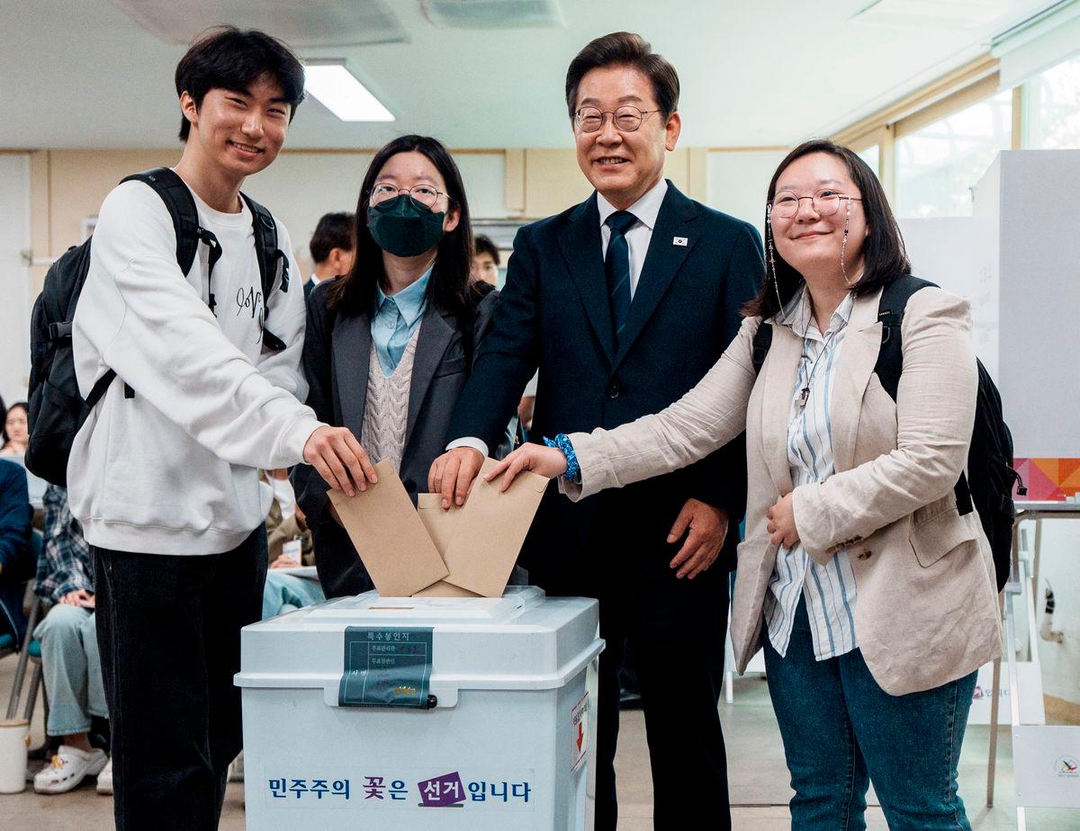 Lee Jae-myung, the presidential candidate for South Korea’s Democratic Party, poses for photographs as he casts his early vote for t he upcoming presidential election with his supporters at a polling station in Seoul, South Korea, May 29, 2025.Yonhap via REUTERS