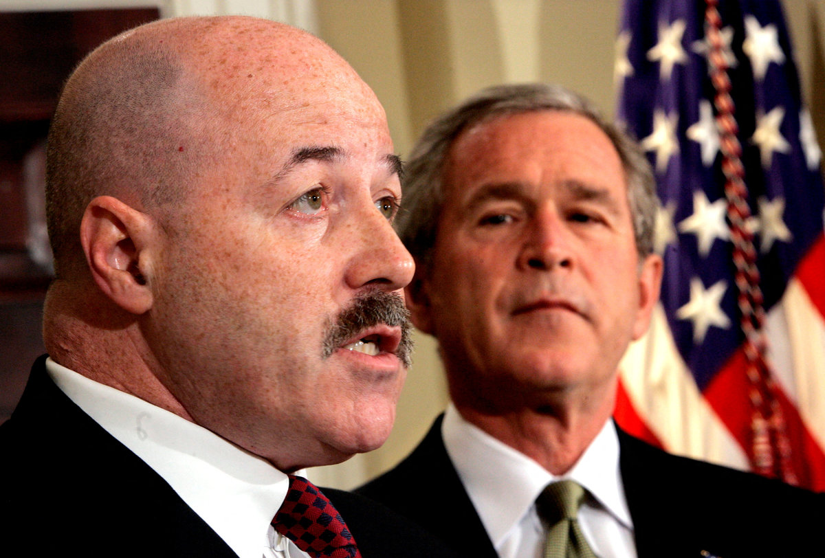 FILE PHOTO: U.S. President George W. Bush listens to remarks after he announced that former New York City police commissioner Bernard Kerik (L), who helped the city respond to the September 11, 2001, attacks and trained Iraqi police, will become the new homeland security secretary, December 3, 2004. REUTERS/Kevin Lamarque/File Photo