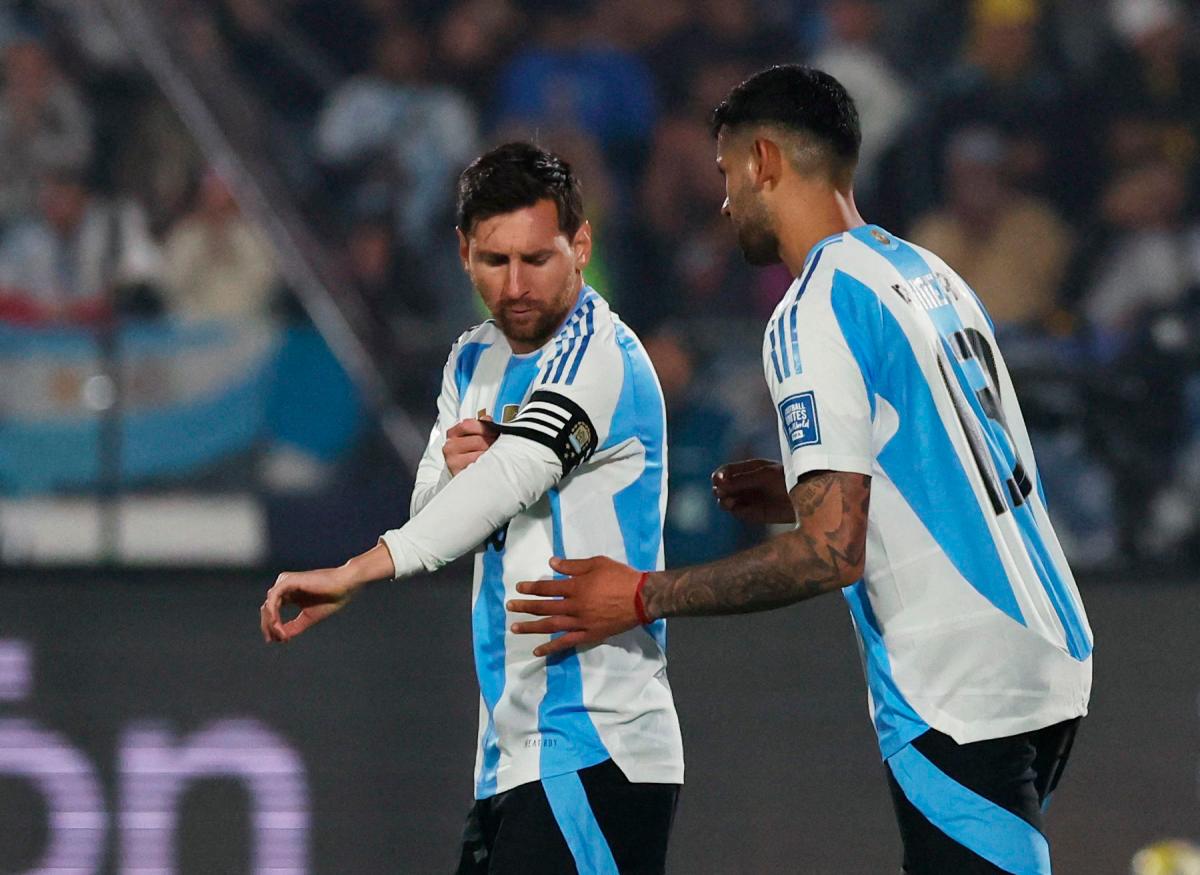 Argentina’s Lionel Messi receives the captains armband from Cristian Romero during the match REUTERS