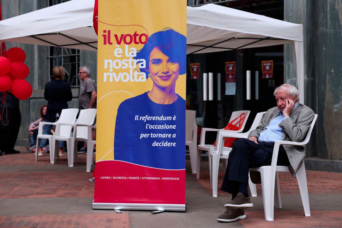 A man sits next to a banner reading 'the vote is our revolt', during a campaign on five abrogative popular referendums regarding employment and Italian citizenship, in Milan, Italy, June 4, 2025. - REUTERSPIX