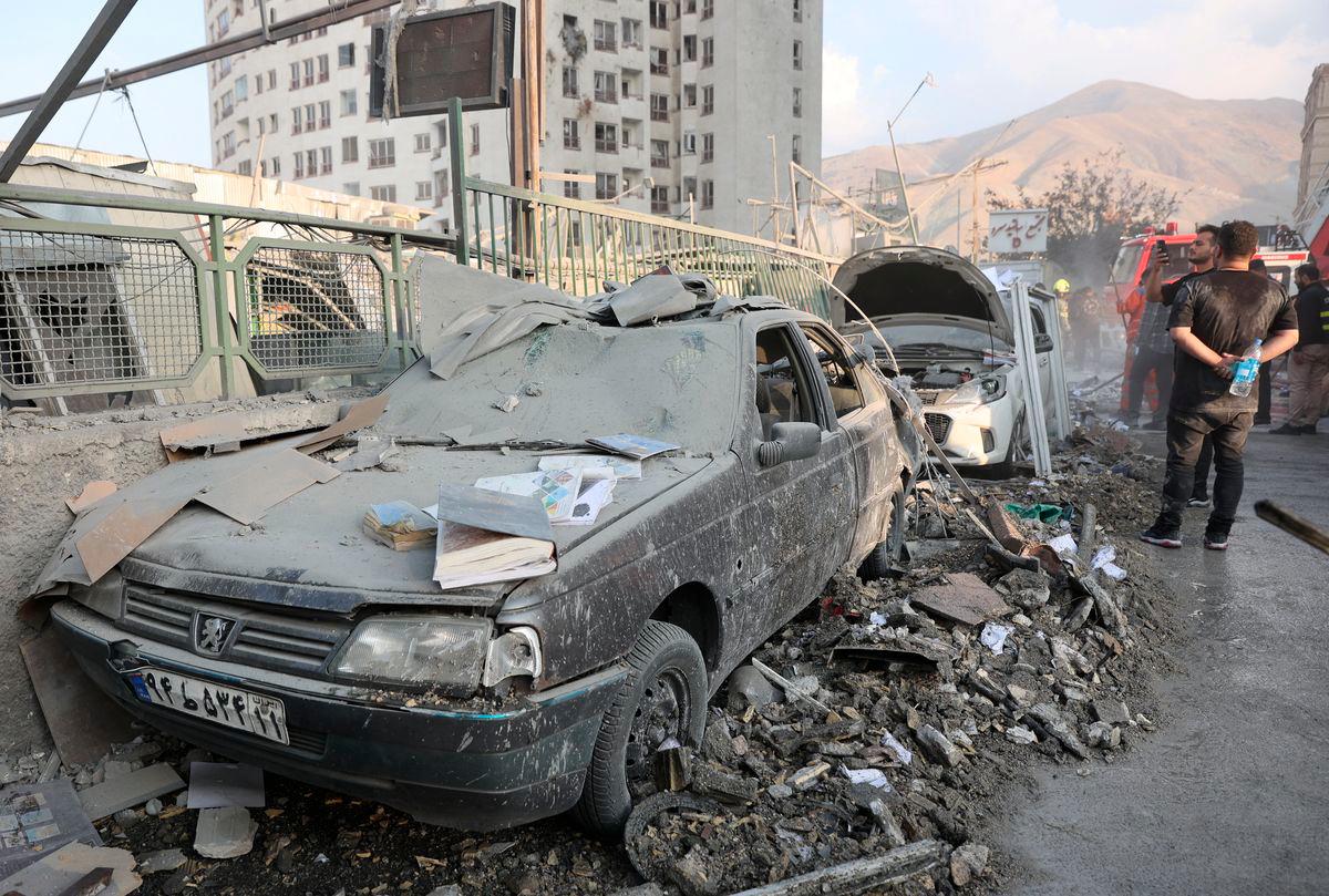 People gather near damaged vehicles in the aftermath of Israeli strikes, in Tehran, Iran, June 13, 2025. - REUTERSPIX