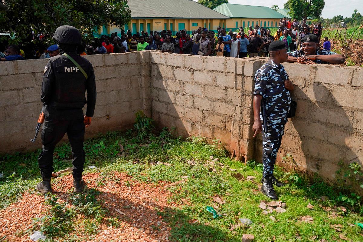 People gather as security personnel stand guard during a visit of government officials following a deadly gunmen attack in Yelewata, Benue State, Nigeria, June 16, 2025. - REUTERS/Marvellous Durowaiye