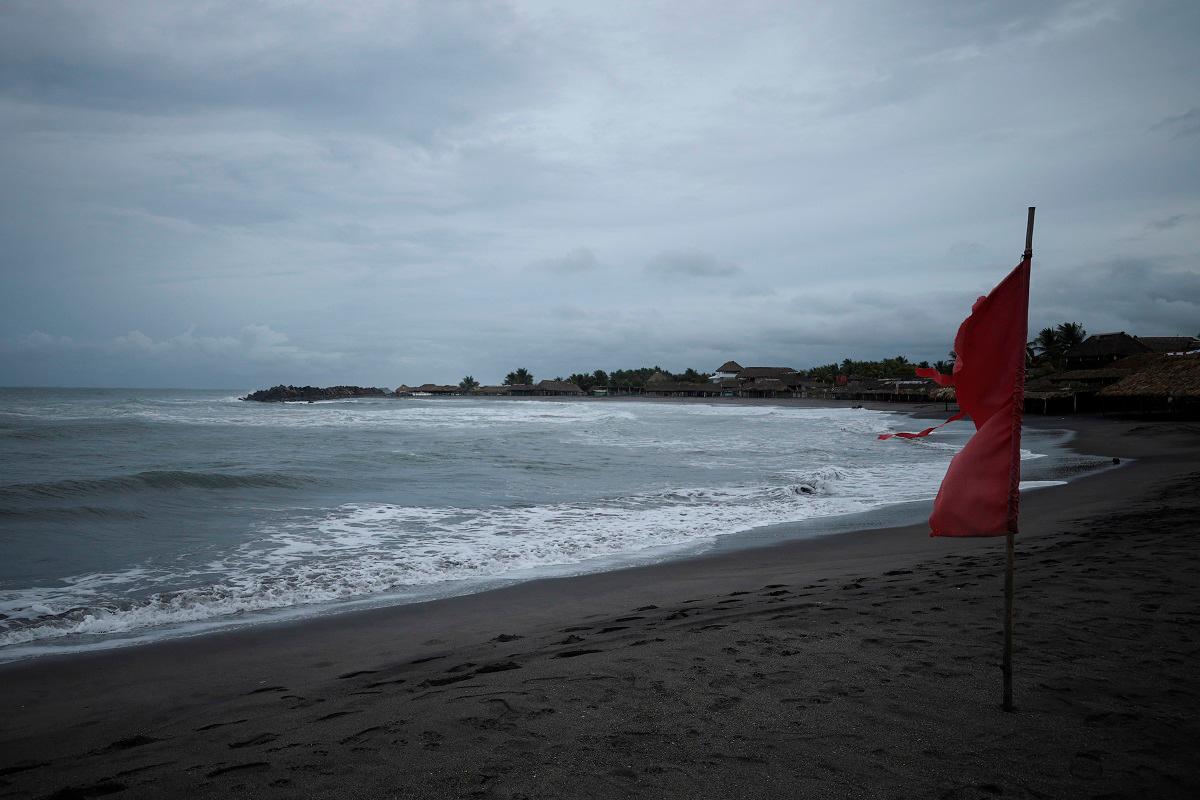 A red flag flutters in the wind, warning beachgoers of dangerous conditions as Tropical Storm Erick strengthens off Mexico’s Pacific Coast, in San Benito, Chiapas state, Mexico, June 17, 2025. - REUTERS/Damian Sanchez