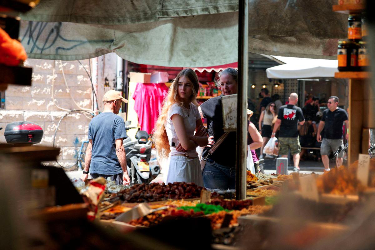 People walk past and observe market stalls selling Middle Eastern produce, in Tel Aviv, Israel, June 27, 2025. - REUTERSPIX