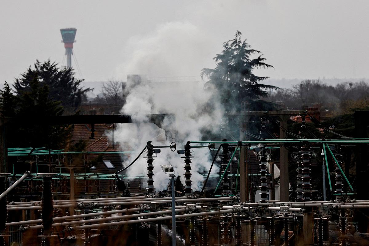 Smoke rises from the area of an electrical substation, with a control tower from the Heathrow International Airport on the background, after a fire there wiped out the power at the airport, in Hayes, London, Britain, March 21, 2025. - REUTERS/Carlos Jasso/File Photo