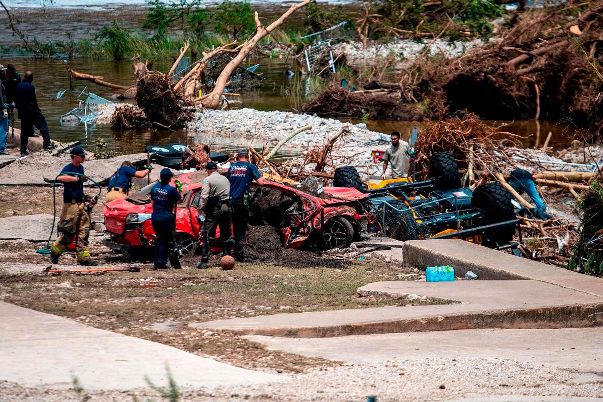 First responders attend to a vehicle pulled from the water in the aftermath of deadly flooding in Kerrville, Texas, U.S., July 6, 2025. - REUTERS/Sergio Flores