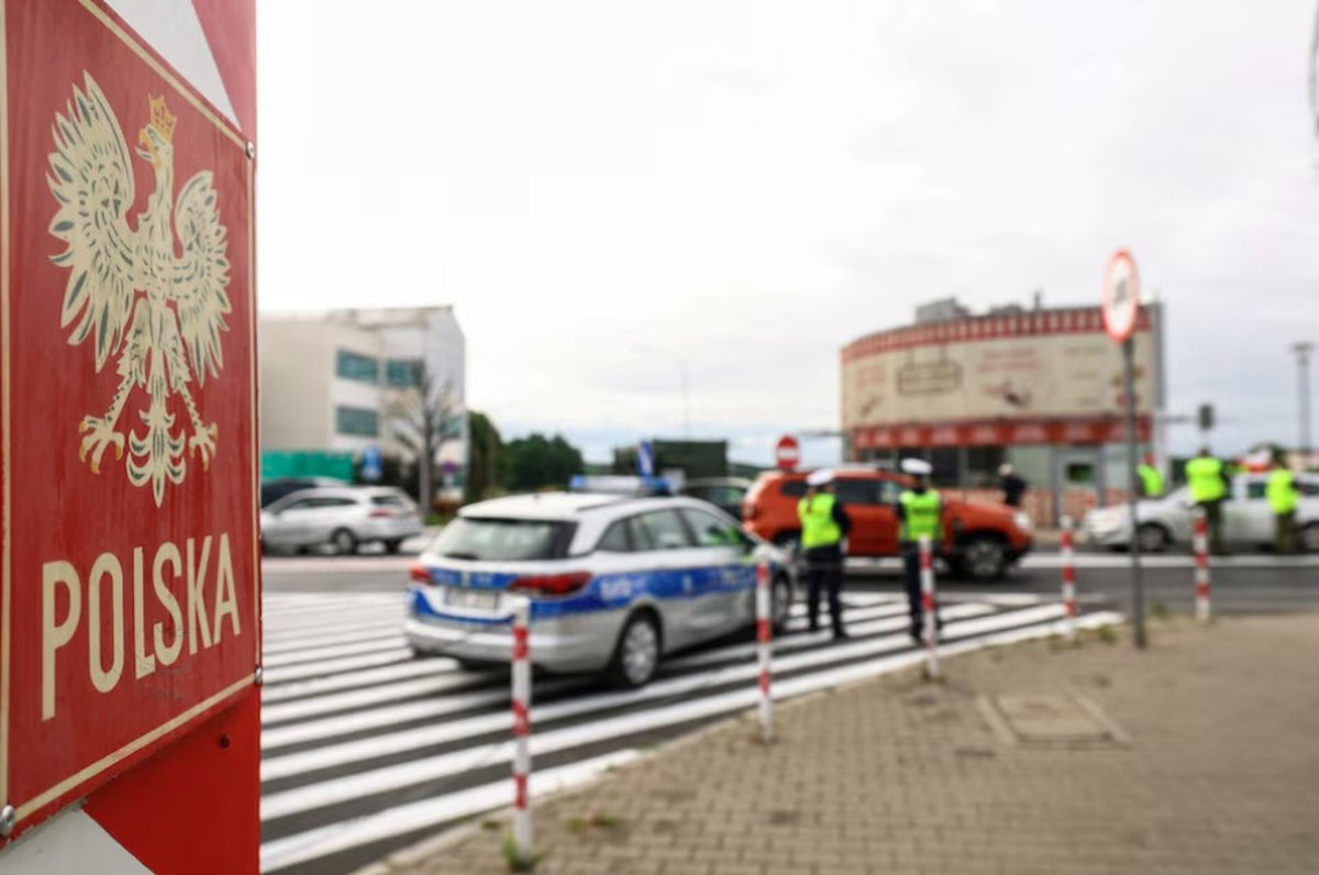 A border stone of Poland is seen as Polish border guards check a vehicle at Polish-German border, as Poland starts controls on borders with Germany, Lithuania over migration, near the German town of Frankfurt an der Oder, in Slubice, Poland, July 7, 2025. - REUTERS
