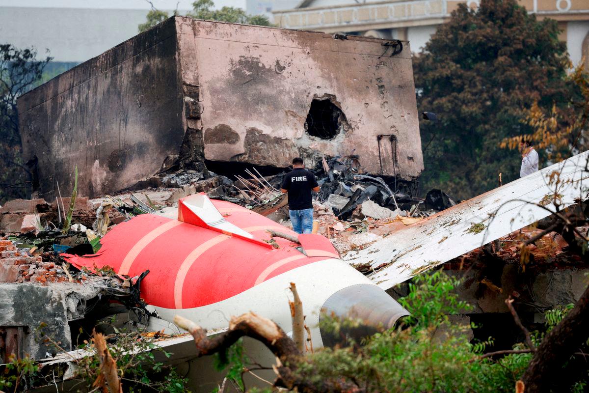 FILE PHOTO: A firefighter stands next to the crashed Air India Boeing 787-8 Dreamliner aircraft, in Ahmedabad, India, June 13, 2025. REUTERS/Adnan Abidi/File Photo