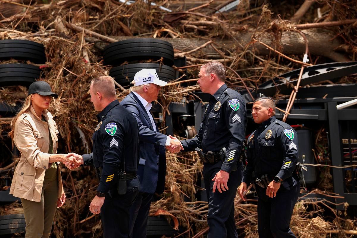 U.S. President Donald Trump and first lady Melania Trump shake hands with Kerrville police officers, as they visit a scene of devastation along the banks of the Guadalupe River, after catastrophic floods, in Kerr County, Texas, U.S., July 11, 2025. REUTERS